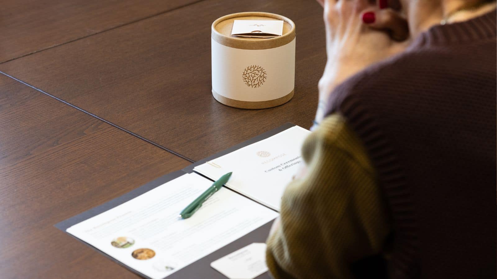 folder with pen in front of someone with hands clasped